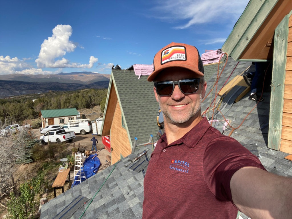 Matt Moomaw, owner of Capitol Exterior on the roof on a sunny day in Boulder Co